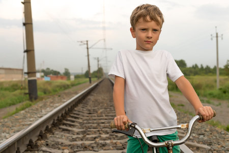 Boy riding a bike outdoors in the grass on a sunny dayの写真素材