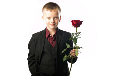 Portrait of a man with a red rose in his hand. Isolated on white background. Boy gives a flower. Guy bought flowers as a gift.の写真素材