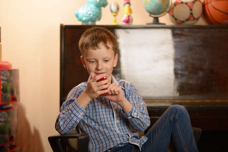 A young man with a cell phone in his hand. Different facial expressions and emotional moods.の写真素材