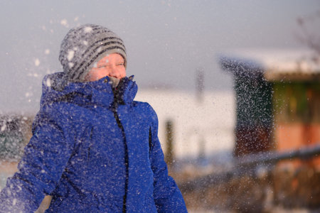 Guy in winter special clothes on a snow-covered field against the backdrop of a countryside...