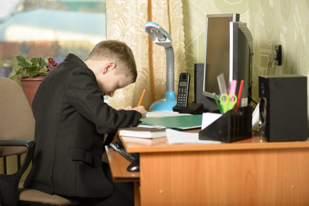 The guy at the office uses computer technology.The schoolboy writes with a pencil in a notebook at...