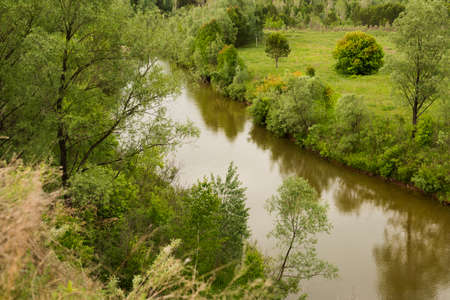 Water barrier, reservoir, river. The place for a travel. Sunny day with clouds in the sky. Green grass and trees.の写真素材
