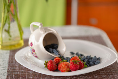 Healthy breakfast from berries. A honeysuckle and strawberry in yogurt. A table in summer cafe. Natural eco-friendly food. Without chemical additives, fragrances and dyes.の写真素材