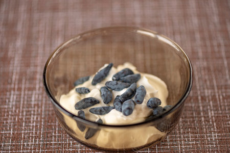 Healthy breakfast from berries. A honeysuckle and strawberry in yogurt. A table in summer cafe. Natural eco-friendly food. Without chemical additives, fragrances and dyes.の写真素材