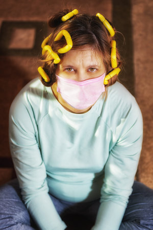 Home insulation. Medical mask . Protective agent. Self-care in the epidemic. Dealing with your appearance. The desire to be well-groomed . Women's mood in the pandemic.の写真素材