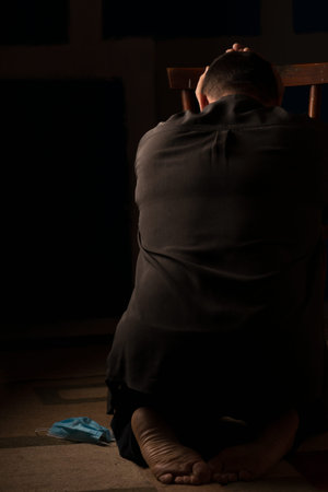 The man is immersed in reflections on future life. Located with his back to the viewer. In a dark...