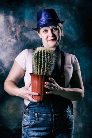 Man woman demonstrates houseplant cactus. Flower protector, prickly amulet. Feng Shui symbol of wealth and prosperity. Happiness in the house and strong energy. Gift is not a good omen.の写真素材