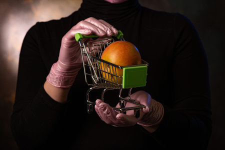 Trolley for transporting goods. Safety and consumer protection from the virus. Delivery of fruit from the store. Tangerines and apples.の写真素材