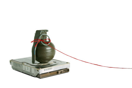 Hand grenade on top of a hard disk drive with red string attached to the pin. Good for demonstrating...