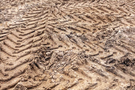 Traces of a bulldozer in the sand. The construction site is rammed with machinery.の写真素材