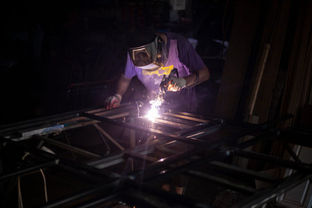 The welder processes the metal. Red-hot material.