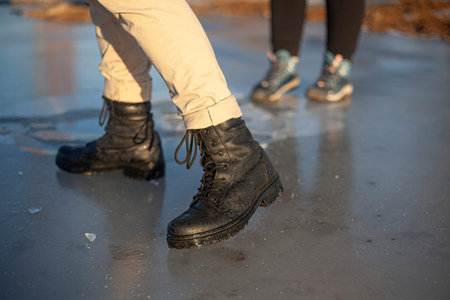 Army boots in the winter. A girl is standing on the ice.
