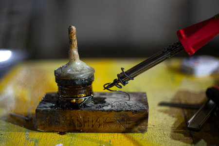 Blowtorch on the table. Tool for fusion of metals. Work in the workshop. Manual labor. An electric...