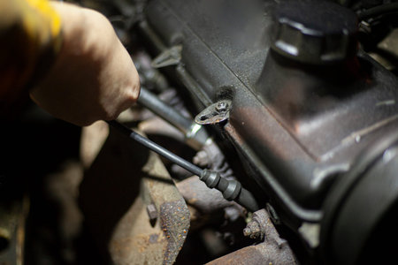 Crash on the road. Car repair. Engine on the hood. A man is looking for a breakdown in his car. Details of the construction of personal vehicles. Diagnosis of damage inside the mechanism.の写真素材