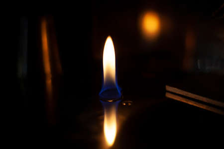 Tongue of fire flame in the dark. Ignition of oxygen in space. Fiery background. Fire of ether in the absence of light. Abstract fire heat background. Single fire. The ignition gel is on.の写真素材