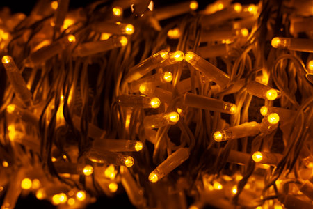 New Year's garlands were densely strewn with darkness lights. Yellow lanterns are randomly scattered...