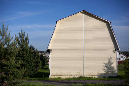 White country house. Country plots out of town. Cheap homes. Rental of small holiday homes. The building is made of white materials. Lawn around the house.の写真素材