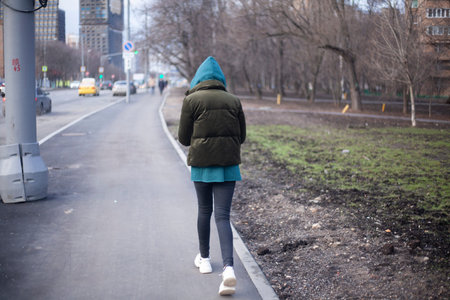 A girl is walking around the city. A teenager walks alone. Unknown person in the hood. The man did...