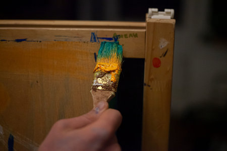 The artist paints with a brush on an easel. Oil paints. Abstract art. Colorful background....
