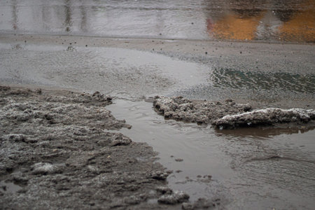 Dirty water flows down the road. Non-working stormwater accumulates waste water. A stream of sewage...