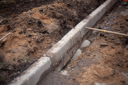 Installation of curbs on the road. Broken asphalt. Removing the top layer of the road. Excavation of...