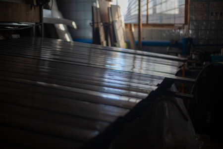Painting boards in the workshop. Painted tree. Gray color on the uneven bars. The work of a house...