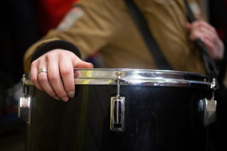The drummer holds his musical instrument. The hand lies on the drum. Member of the orchestra....