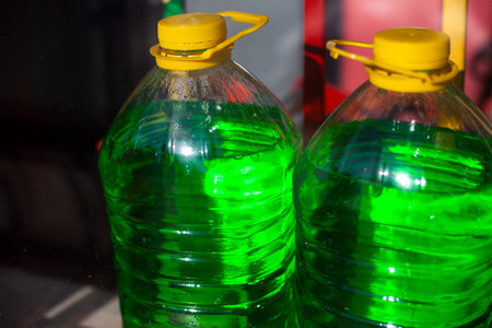 Liquid for the car. Green water in a bottle. Non-freezing liquid for processing transport windows.