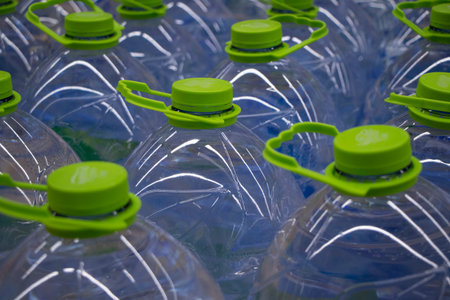 Water in cans. A lot of bottles with liquid. Fresh water supply in vessels. A store counter with...