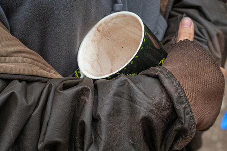 Mug with a drink in the girl's hand. Simple unwashed cup background.