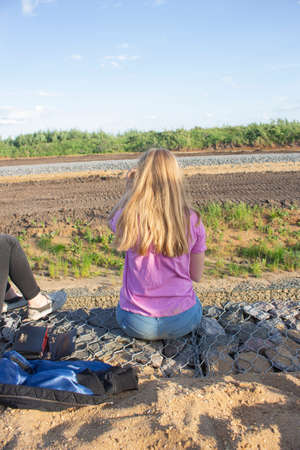 Girl in the country. A teenager is dreaming. Beautifully dressed girl. Fashion among youth. A typical summer day in children. The experiences of a young lady.の写真素材