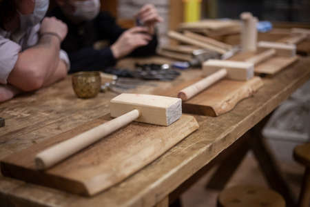 Wood workshop. Hammers are on the table. The class is prepared for the lesson on wood processing. Wooden hammers in the workplace. Vintage objects for shooting.の写真素材