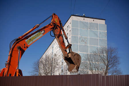 Heavy machinery at a construction site. An excavator drips the ground with a bucket. Worth the work. Communications preparation. Excavations on the landscape. Raising the earth.の写真素材