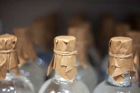 Bottles stand in a row in a store. Alcoholic picti on the counter. Transparent vessels with vodka. Preparing for the evening.の写真素材