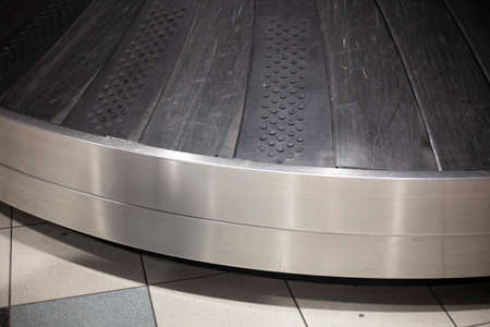 Baggage at the airport. Waiting for things. Means for transporting luggage. Bags ride on a belt road. Transportation of things after the flight. Luggage arrival delay at city airport.の写真素材