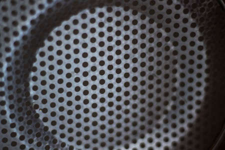 A kitchen item in the hole for filtering water. Metal mesh texture. Background from a plain silver steel object.の写真素材