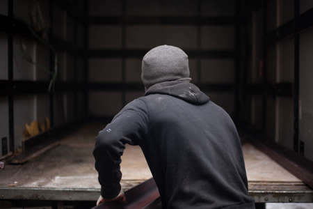 Loaders are loading metal into a lorry. Transportation of heavy industrial products. Men do their job. Small business transporting products. Black work for guys.の写真素材