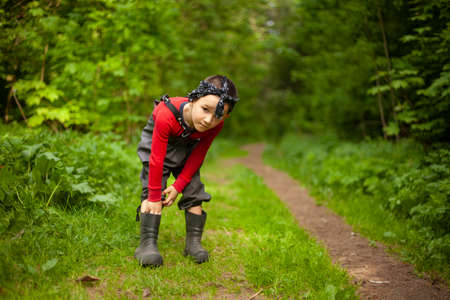 A child in the summer forest. Preschool boy on a walk in nature. Seeker of adventures. Shooting a child on a sunny and warm day.の写真素材