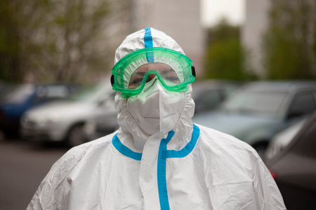 A doctor in a protective suit on the street. Infectionist in a mask and glasses. A paramedic came to...