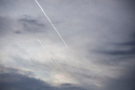 Airplane trail in the evening sky. A passenger plane is high in the atmosphere. Line in open space....