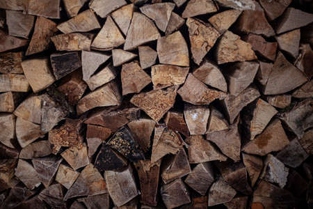 Woodpile with firewood. Harvesting for the winter. Dry wood heating. The texture of chopped bars.の写真素材