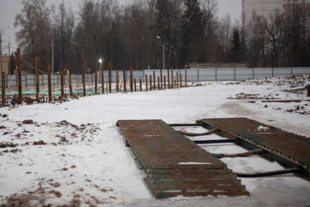 Construction in the winter. Entrance to the construction site. Fenced space to create the foundation of the building.の写真素材