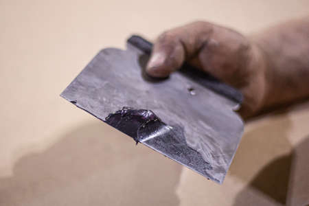 Putty applied to the spatula. Tool for smoothing surfaces. Repair in the workshop.の写真素材