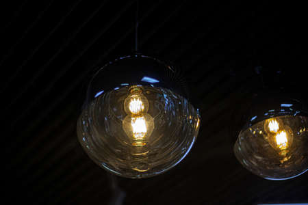 Fancy lamps on the ceiling. Glowing balls. Indoor lighting design. Spherical transparent containers for diffusing light. The interior decoration of the ceiling.の写真素材