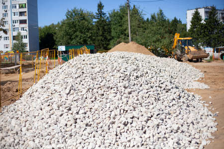 Building stone lies in a heap. Material for building the foundation of the house. Construction site. Preparation for the construction of a residential building.の写真素材