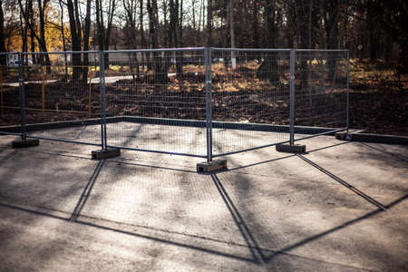 Fencing holes in the ground. Prokdaka heating pipes. Metal fence on the street.の写真素材