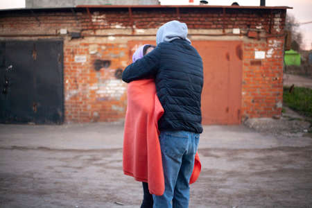 The guy with the girl is hugging. Sweet couple kiss. Relations between a man and a woman. They meet. Tenderness and warmth of hugs.の写真素材