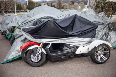 The motorcycle is covered with an awning from the rain. Workshop for electric vehicles. Parking bikes. Storage from precipitation. Electric vehicle rental.の写真素材