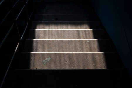 Steps in the house. Concrete steps on the stairs. Natural light falls on the floor. Abstract household background.の写真素材