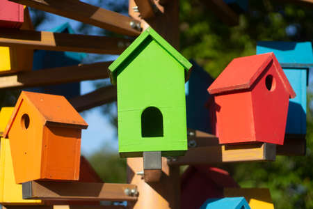 Bird houses. Colored birdhouses on the street. Decoration in the city park for feeding birds. Multi-colored small houses made of wood.の写真素材